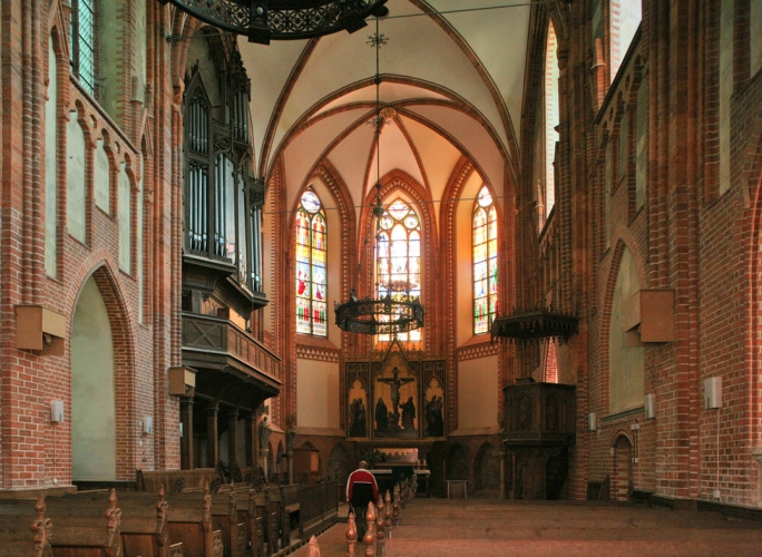 Blick in den Chor mit Altar und Buntglasfenstern.